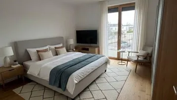 Helles Schlafzimmer mit Holzboden, großem Bett und Zugang zu einem französischen Balkon.