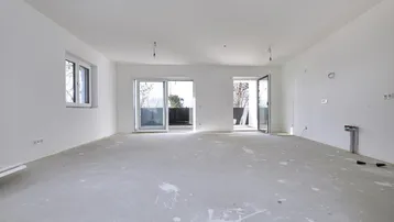 Heller, unfertiger Wohnbereich mit großen Schiebetüren und Zugang zu einem Balkon.
