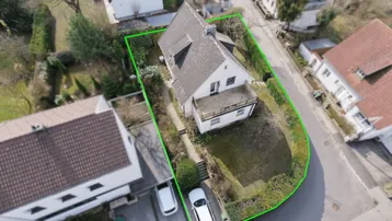 Luftaufnahme eines Einfamilienhauses mit Garten und Grundstücksgrenze in ländlicher Umgebung.