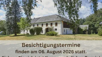 Historisches Gebäude mit weitläufigem Grundstück, umgeben von grüner Natur und altem Baumbestand.