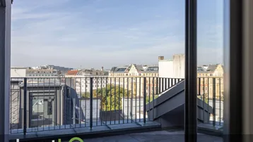 Geräumige Dachterrasse mit Fliesenboden und weitem Blick über die Stadt.
