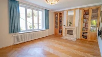 Klassisches Wohnzimmer mit Kamin, Einbauschränken und Parkettboden.