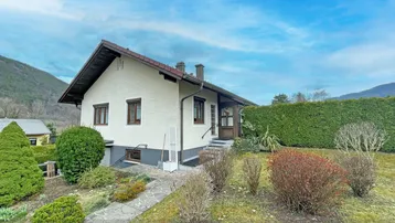 Einfamilienhaus mit Garten und Bergblick in ländlicher Umgebung.