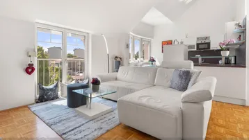 Helles Wohnzimmer mit weißem Sofa, Parkettboden und Zugang zu einem französischen Balkon.