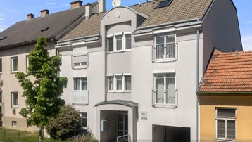 Vorderansicht eines Mehrfamilienhauses mit klassischer Fassade und Eingangsbereich.