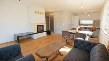 Geräumiger Wohn- und Essbereich mit Kamin, Holzboden und offener Gestaltung.