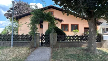 Einfamilienhaus mit gepflegtem Vorgarten und traditionellem Zaun in ländlicher Umgebung.