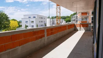 Unfertiger Balkon eines Neubaus mit Blick auf die Umgebung und weitere Bauprojekte.