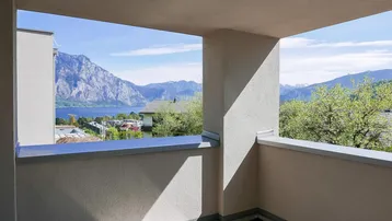 Balkon im Bau mit weitem Blick über den See und die malerische Berglandschaft.