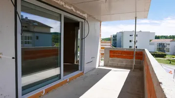 Unfertiger Balkon im Rohbau mit Blick auf die Umgebung und andere Gebäude.