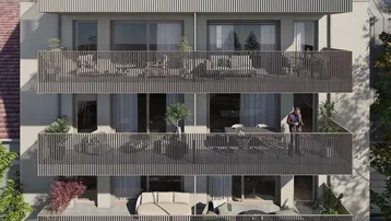 Moderne Wohnanlage mit mehreren Balkonen und einer großzügigen möblierten Terrasse im Erdgeschoss.