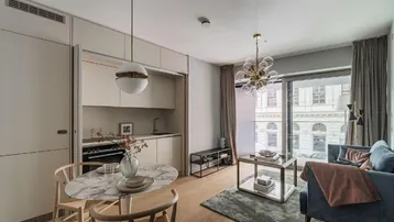 Moderner offener Wohn- und Essbereich mit integrierter Küchenzeile und Blick auf die Stadt.