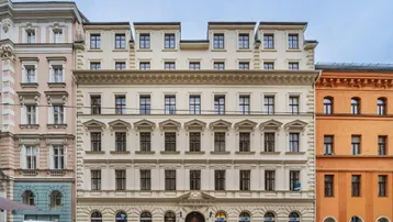 Historisches Gebäude mit klassischer Fassade und vielen Fenstern an einer Stadtstraße.
