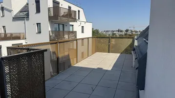 Große Dachterrasse mit modernen Metallgeländern und weitem Blick über die Stadt.