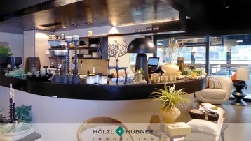 Modern gestalteter Innenbereich mit geschwungener Theke und stilvoller Dekoration, ideal für eine Lounge oder Bar.