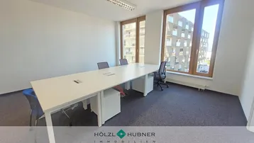 Großes, helles Büro mit modernem Konferenztisch und Blick auf die umliegenden Gebäude.