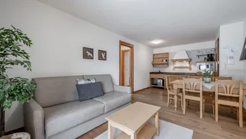 Gemütlicher offener Wohn- und Essbereich mit integrierter Küche und Holzboden.