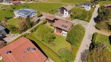 Luftaufnahme eines Wohngebiets mit Einfamilienhäusern, Gärten und grüner Umgebung.
