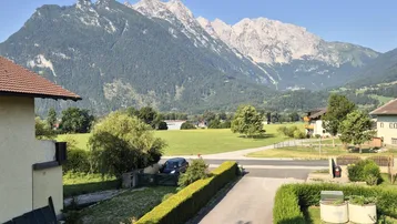 Malerischer Blick auf majestätische Berge und weite grüne Felder von der Immobilie aus.