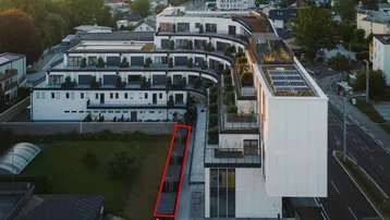 Moderne Wohnanlage mit begrünten Dächern und Balkonen aus der Vogelperspektive.