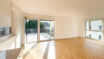 Heller, leerer Wohn-Essbereich mit Eichenparkett, großen Fenstern und direktem Zugang zur Terrasse.