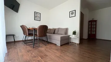 Heller Wohn- und Essbereich mit Holzboden, Esstisch und bequemer Couch für gesellige Abende.