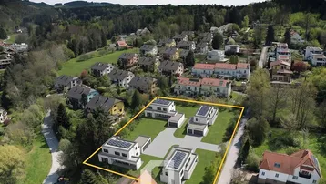 Luftaufnahme einer neuen Wohnsiedlung mit modernen Häusern und grüner Umgebung.