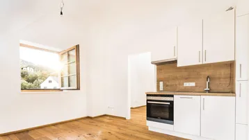 Helle Dachgeschosswohnung mit integrierter Küchenzeile, Holzboden und Blick ins Grüne.