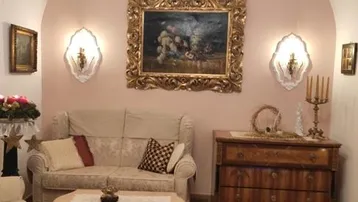 Gemütliches Wohnzimmer mit gewölbter Decke, rosafarbenen Wänden und traditionellen Holzmöbeln.
