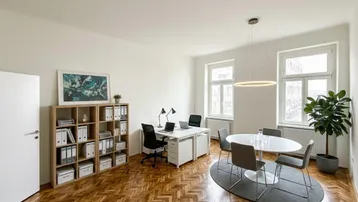 Geräumiges Büro mit Fischgrätparkett, zwei Arbeitsplätzen und einem Besprechungstisch, hell durch große Fenster.
