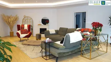 Gemütliches Wohnzimmer mit hellem Parkettboden, modernen Möbeln und einem dekorativen Kamin.