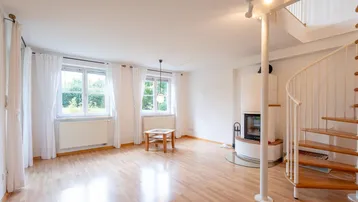 Helles Wohnzimmer mit Parkettboden, Kamin und eleganter Wendeltreppe.