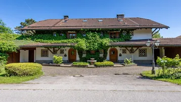 Traditionelles Haus mit üppigem Efeu an der Fassade und zwei einladenden Eingängen.