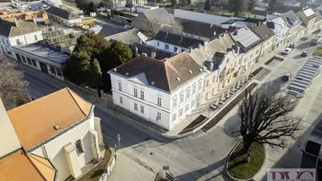 Luftaufnahme des historischen Gebäudes im Zentrum einer Kleinstadt mit umliegender Landschaft.