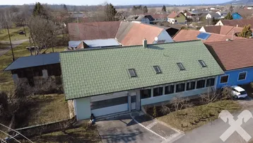 Luftaufnahme des Anwesens mit grünem Dach und umliegender ländlicher Bebauung.