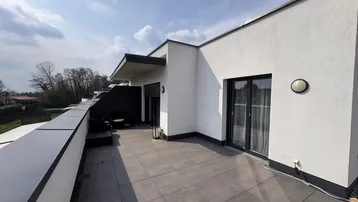 Geräumige Dachterrasse mit modernen Fliesen und Blick auf die Umgebung.