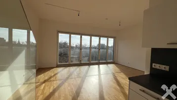 Lichtdurchfluteter Wohnbereich mit Holzboden und breiter Fensterfront, die einen weiten Ausblick bietet.