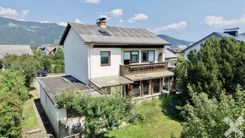 Freistehendes Haus mit Balkon, Wintergarten und Blick auf die umliegende Berglandschaft.