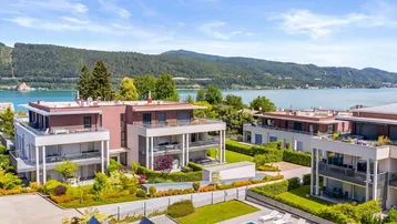 Luftaufnahme einer modernen Wohnanlage mit See- und Bergblick sowie Gemeinschaftspool.