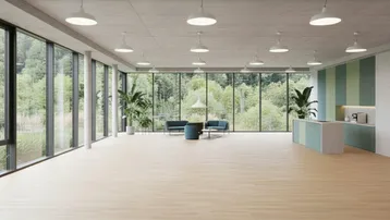 Geräumiges, leeres Büro mit großen Fensterfronten, hohen Decken und einem weiten Blick in die Natur.