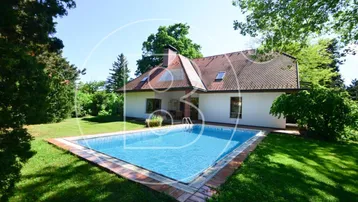 Großzügiger Gartenbereich mit privatem Swimmingpool und Blick auf das charmante Einfamilienhaus.