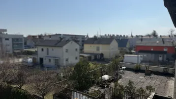 Weitläufiger Blick über die Dächer der Nachbarschaft und umliegende Gebäude an einem sonnigen Tag.
