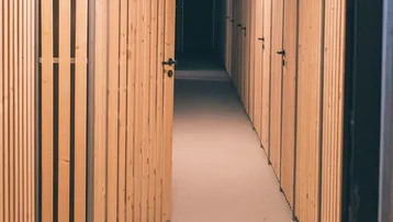 Heller Gang mit modernen Holzverschlägen, die als Lagerräume dienen.
