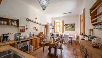 Geräumige Küche im Landhausstil mit Holzarbeitsplatten, einem großen Arbeitstisch und Essbereich.