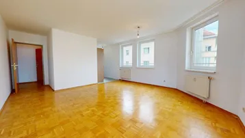 Helles Wohnzimmer mit klassischem Parkettboden, weißen Wänden und mehreren Fenstern für viel Tageslicht.