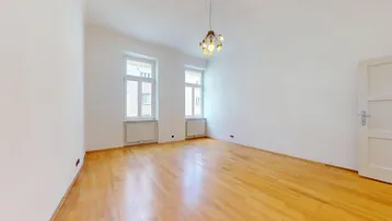 Helles, leeres Zimmer mit Parkettboden, weißen Wänden und zwei Fenstern, bereit zur Einrichtung.