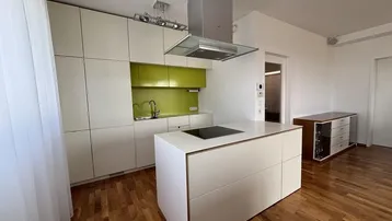 Moderne Küche mit Kochinsel, weißen Hochglanzschränken und einer leuchtend grünen Rückwand.