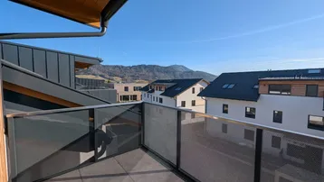 Geräumiger Balkon mit moderner Verglasung und weitem Blick auf die umliegende Berglandschaft.