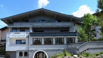 Traditionelles Pensionsgebäude mit alpiner Architektur, mehreren Balkonen und einem gepflegten Eingangsbereich.