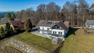 Luftaufnahme des Anwesens mit großem Garten, umgeben von Feldern und Wald.